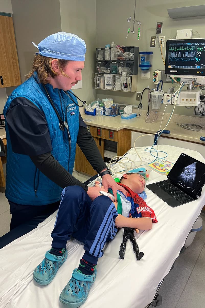 Scheduler reviewing anesthesia coverage calendar with administrator in hospital office.